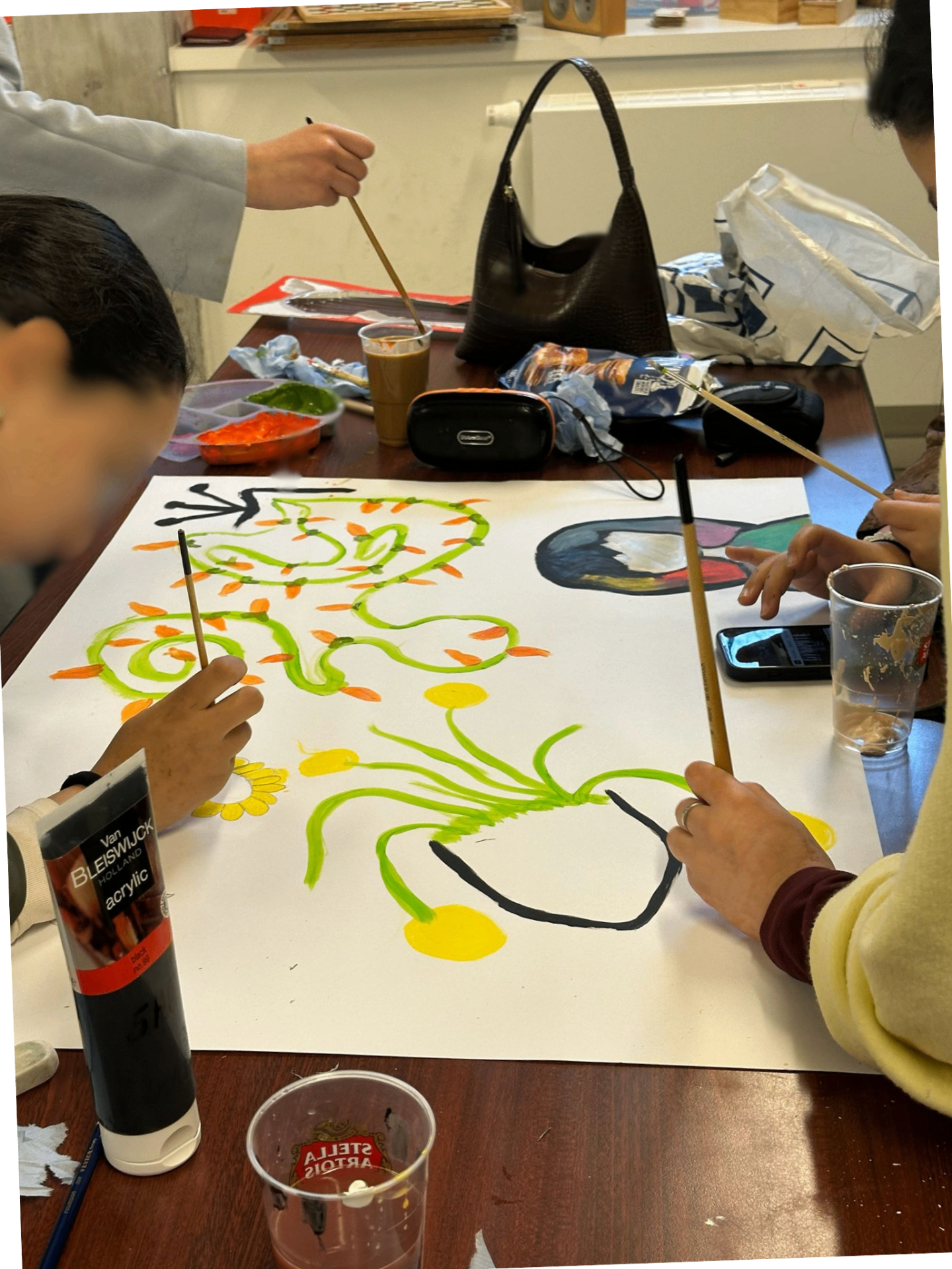 Groep schildert samen aan een groot vel tijdens een KUNST360 atelier